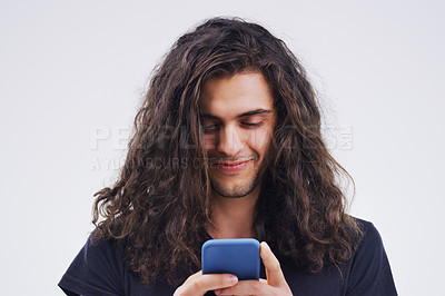 Buy stock photo Phone, typing and face of man in studio for social media post, internet and online chat. Communication, white background and happy male person on smartphone for website, mobile app and networking