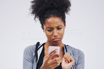 Buy stock photo Studio shot of a young woman using a mobile phone against a grey background