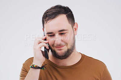 Buy stock photo Chat, phone call and man listening in studio isolated on a white background. Calling, cellphone and male person talking, discussion or speaking, conversation and networking with contact on mobile.