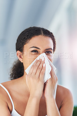 Buy stock photo Cropped shot of an attractive young woman blowing her nose in the bathroom at home