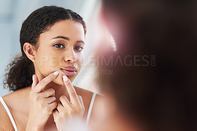Buy stock photo Cropped shot of a beautiful young woman squeezing a pimple in the mirror