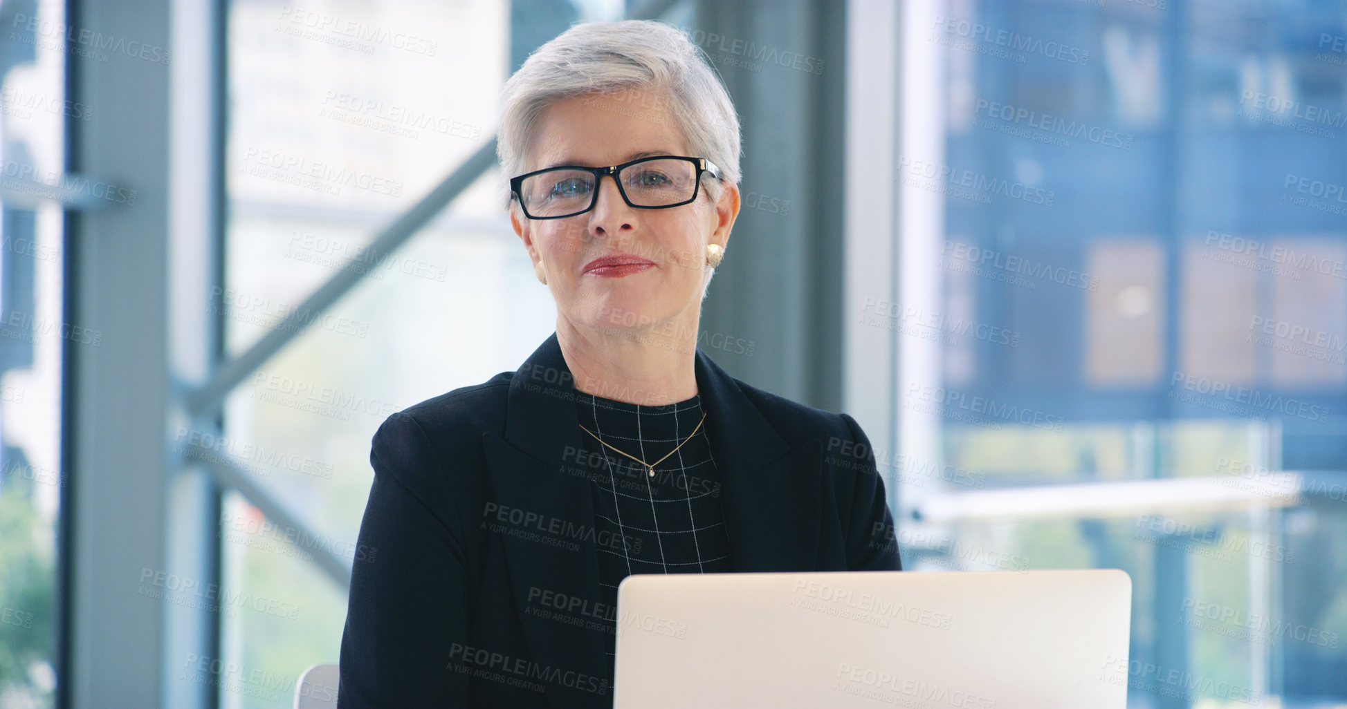 Buy stock photo Portrait of a mature businesswoman working on a laptop in an office