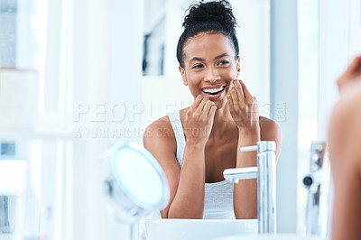 Buy stock photo Cropped shot of an attractive young woman flossing her teeth in the bathroom at home