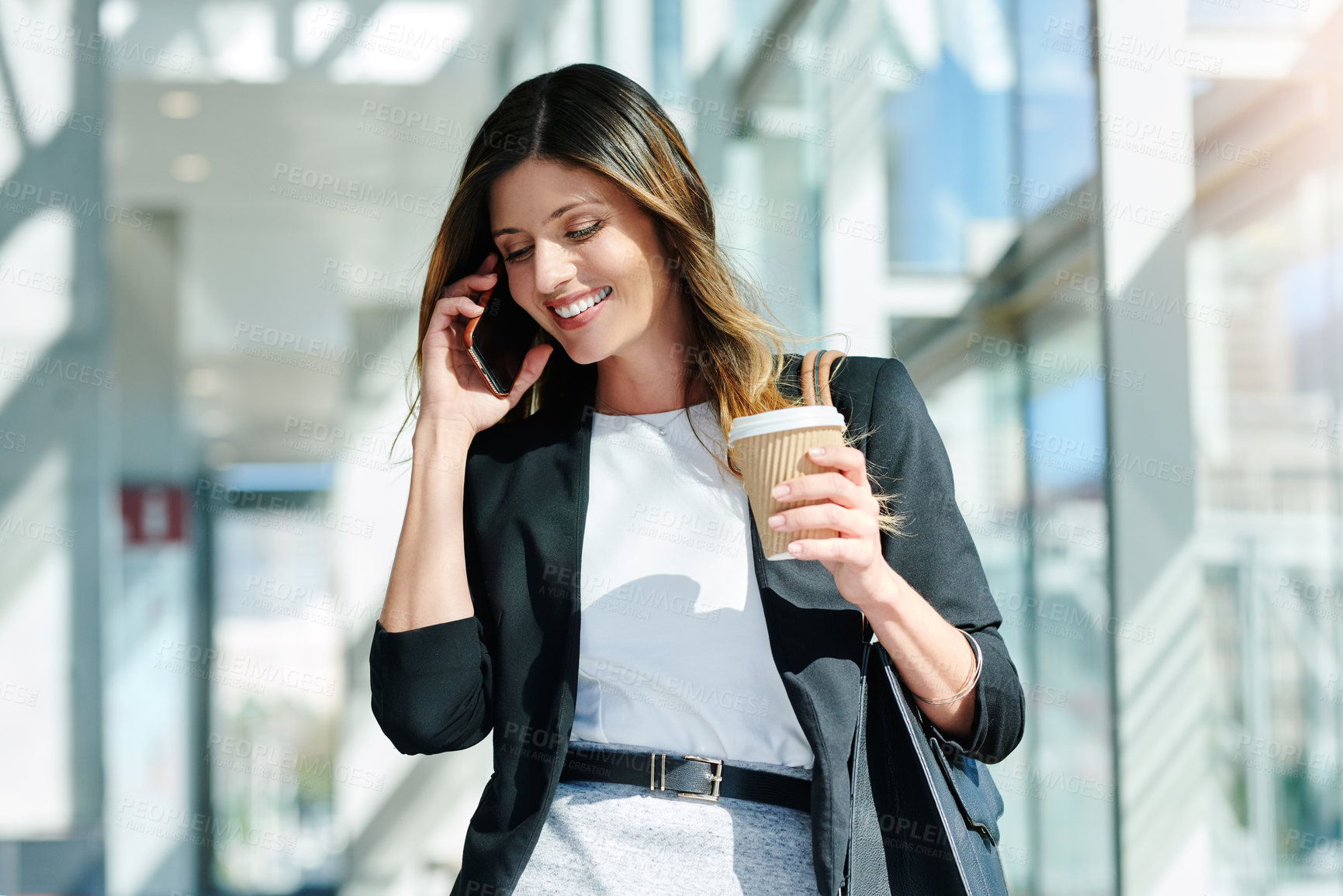 Buy stock photo Cropped shot of an attractive young businesswoman taking a a phonecall while walking through a modern office