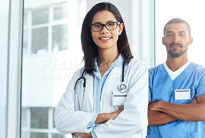 Buy stock photo Portrait of two confident young doctors working in a modern hospital