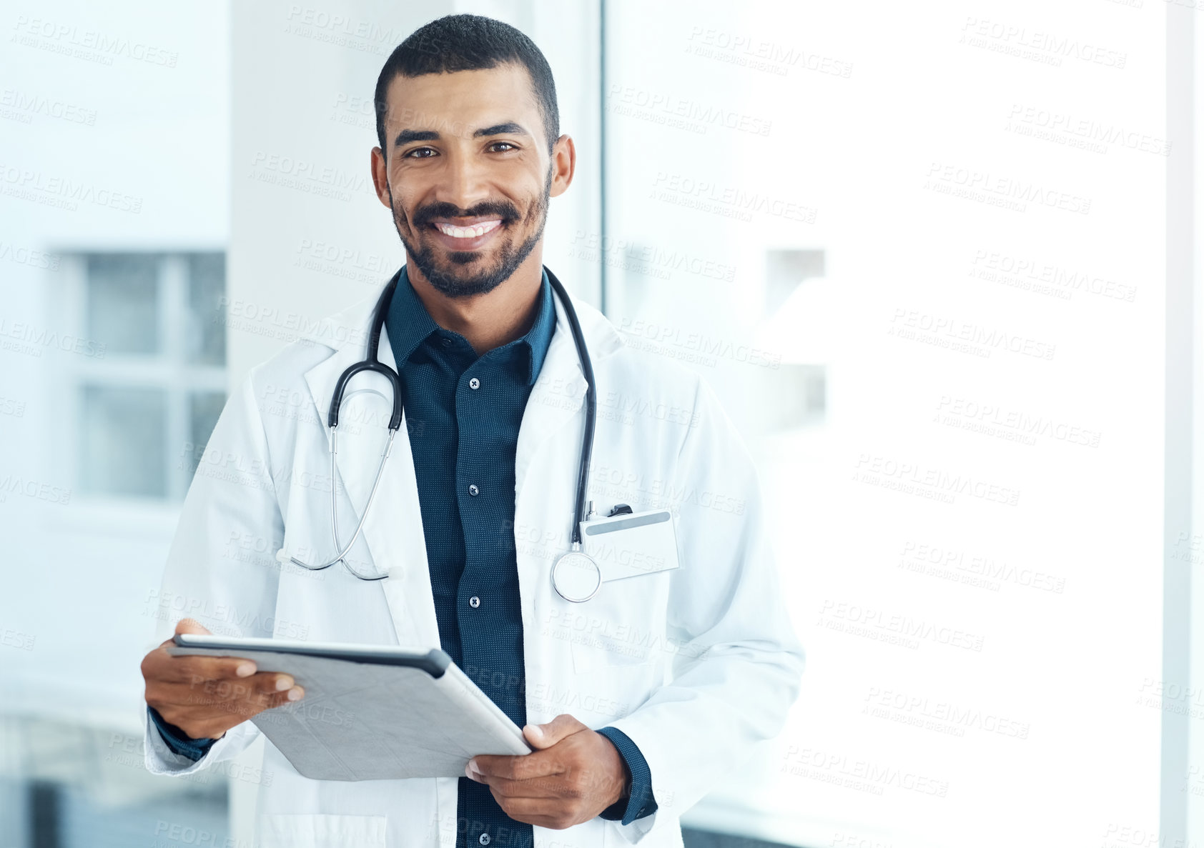 Buy stock photo Portrait of a young doctor using a digital tablet in a modern hospital