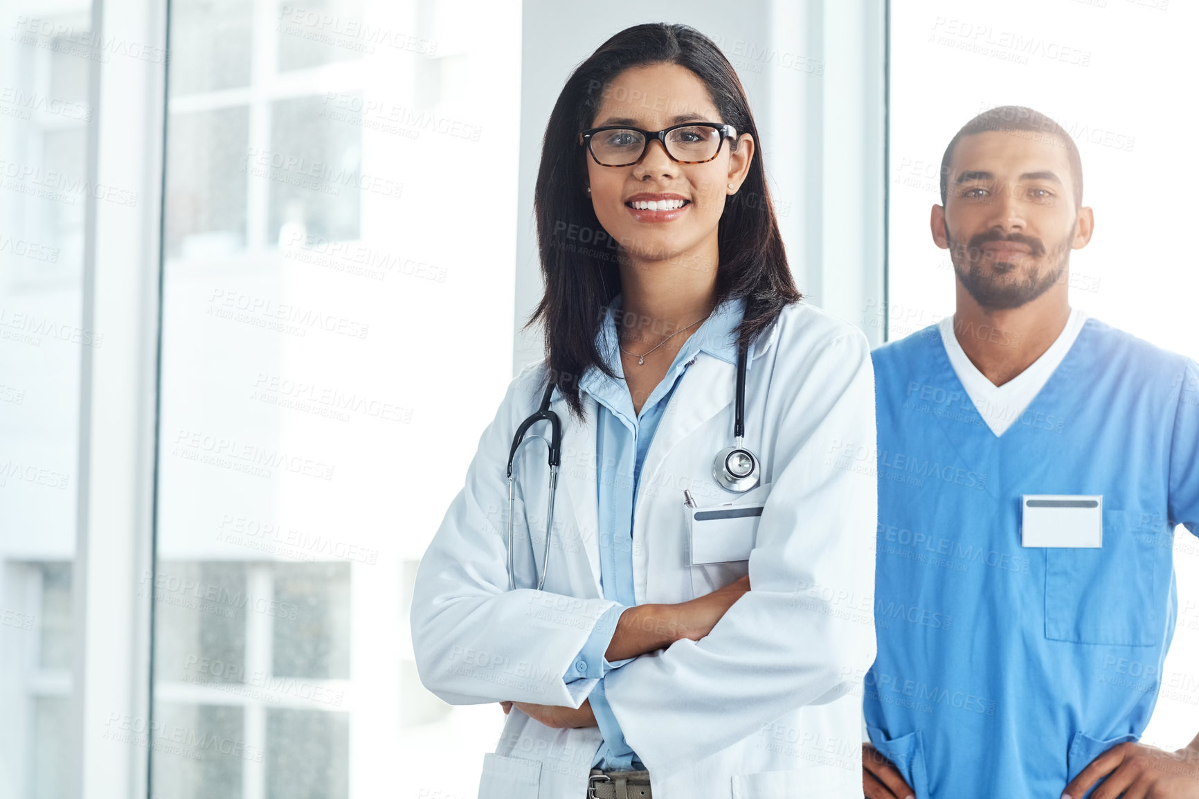 Buy stock photo Portrait of two confident young doctors working in a modern hospital