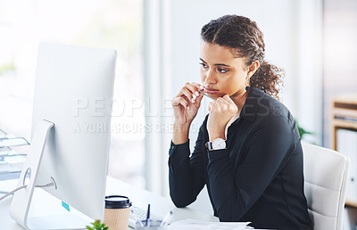 Buy stock photo Shot of a young businesswoman looking bored while working on a computer in an office