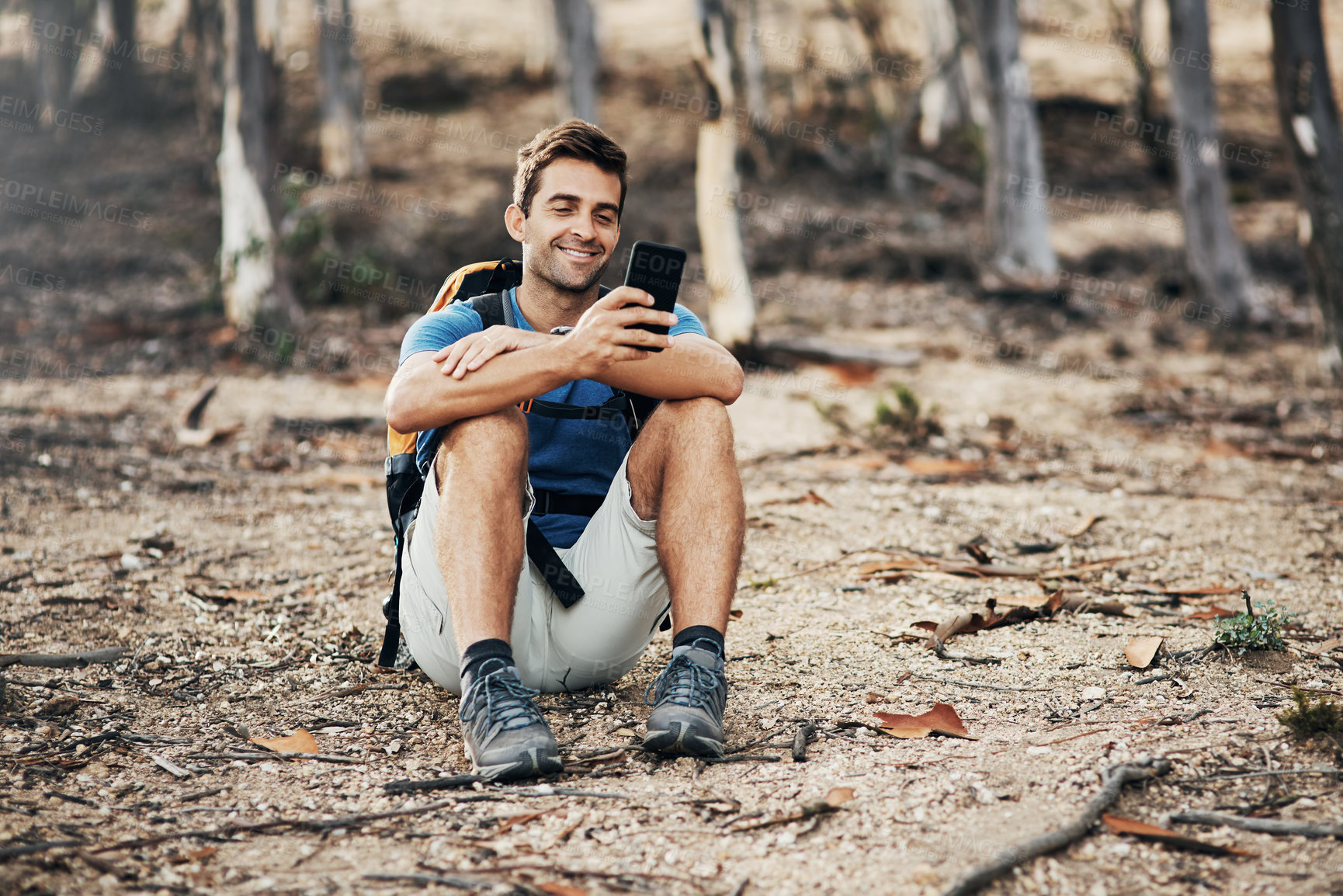 Buy stock photo Man, backpack and nature for adventure, phone and person in woods, fitness and peace in environment. Outdoor, healthy and mobile for communication, reading and explore in forest and relax on ground