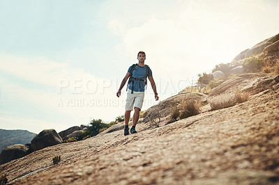 Buy stock photo Cropped shot of a carefree young man going for a hike up a mountain outside during the day