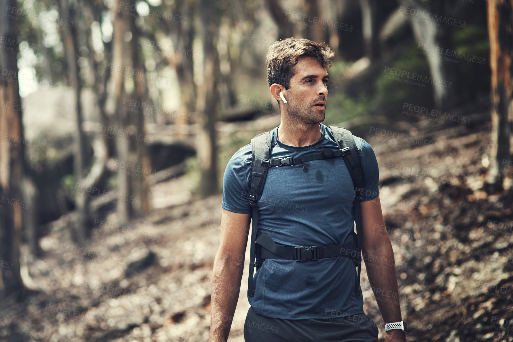Buy stock photo Cropped shot of a handsome young man out for a hike in the mountains