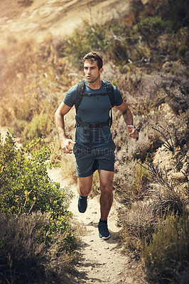 Buy stock photo Full length shot of a handsome young man running during his hike in the mountains