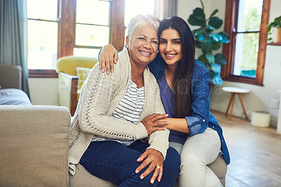 Buy stock photo Portrait of a beautiful young woman posing with her mother while relaxing on a sofa at home
