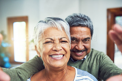 Buy stock photo Portrait of an affectionate senior couple taking a selfie together indoors