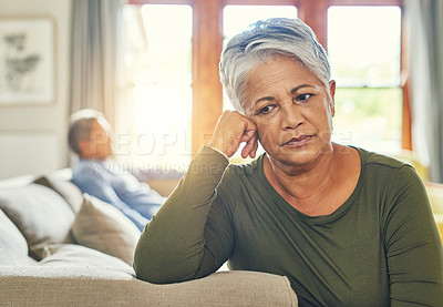 Buy stock photo Shot of a senior couple sitting separately on a couch after having an argument
