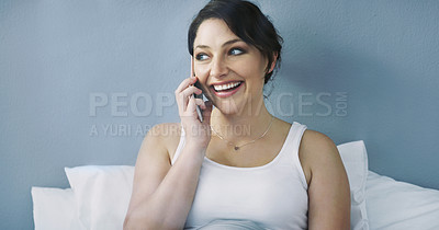 Buy stock photo Cropped shot of an attractive young woman talking on her cellphone while sitting in bed at home