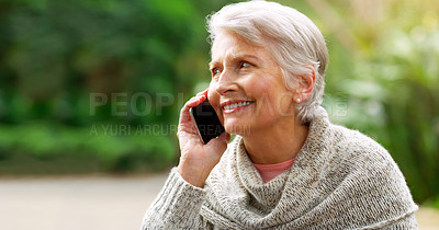 Buy stock photo Cropped shot of a cheerful elderly woman talking on her cellphone outside in a park