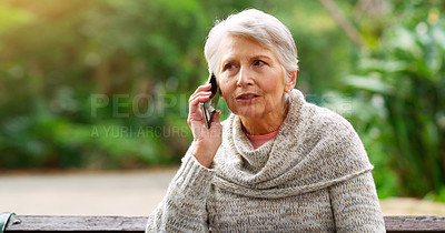 Buy stock photo Cropped shot of a cheerful elderly woman talking on her cellphone while being seated on a bench outside in a park during the day