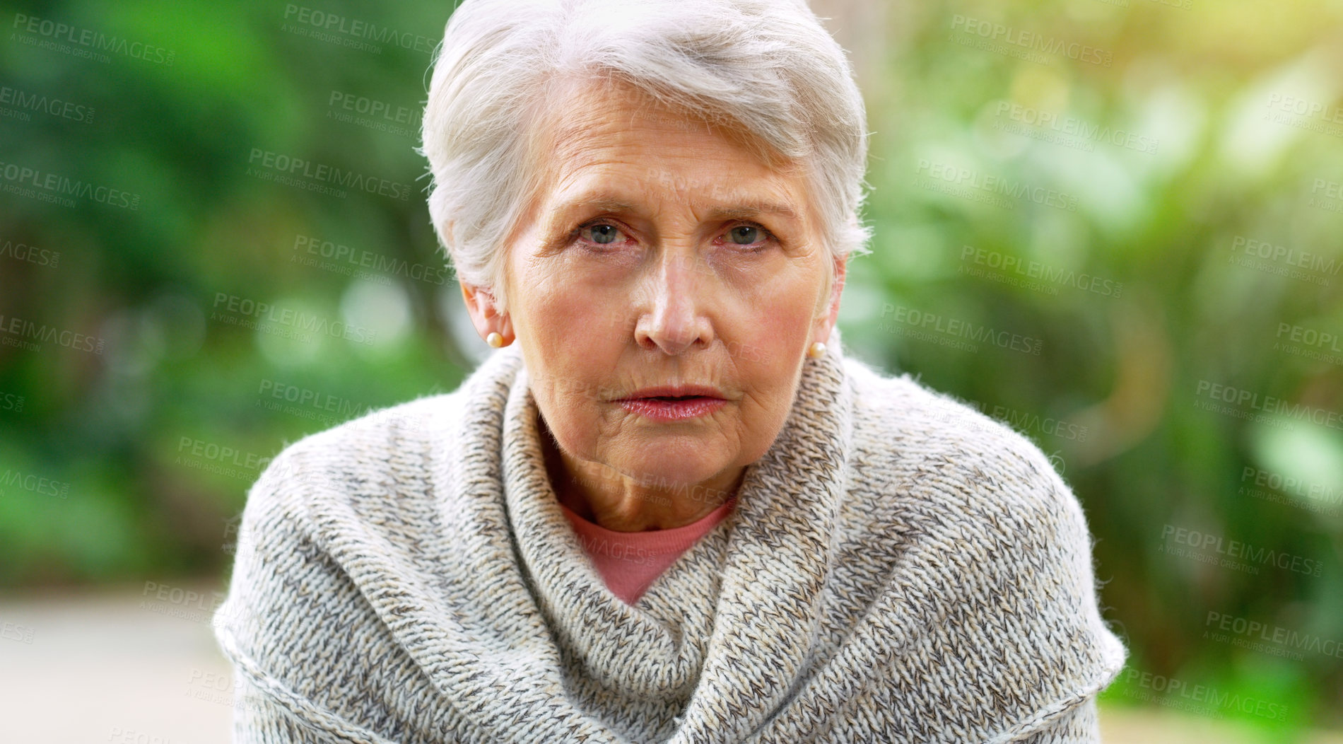 Buy stock photo Portrait of a carefree elderly woman seated on a bench while contemplating outside in a park