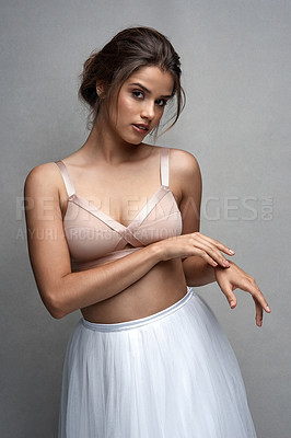 Buy stock photo Studio portrait of an attractive young female ballet dancer posing against a grey background