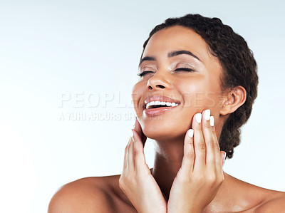 Buy stock photo Studio shot of an attractive young woman posing while touching the sides of her face against a white background