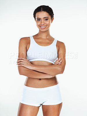 Buy stock photo Portrait of an attractive young woman standing with arms folded against a white background