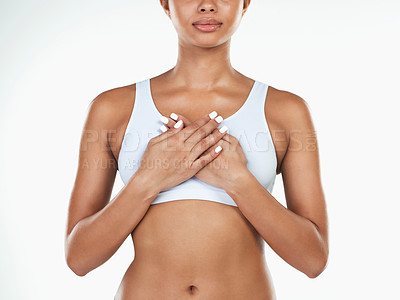Buy stock photo Studio shot of an unrecognizable woman holding her chest while standing against a white background