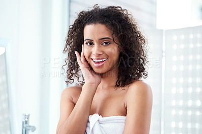 Buy stock photo Shot of a beautiful young woman touching her face while going through her morning routine