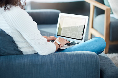 Buy stock photo Shot of an unrecognizable woman using her laptop while relaxing at home