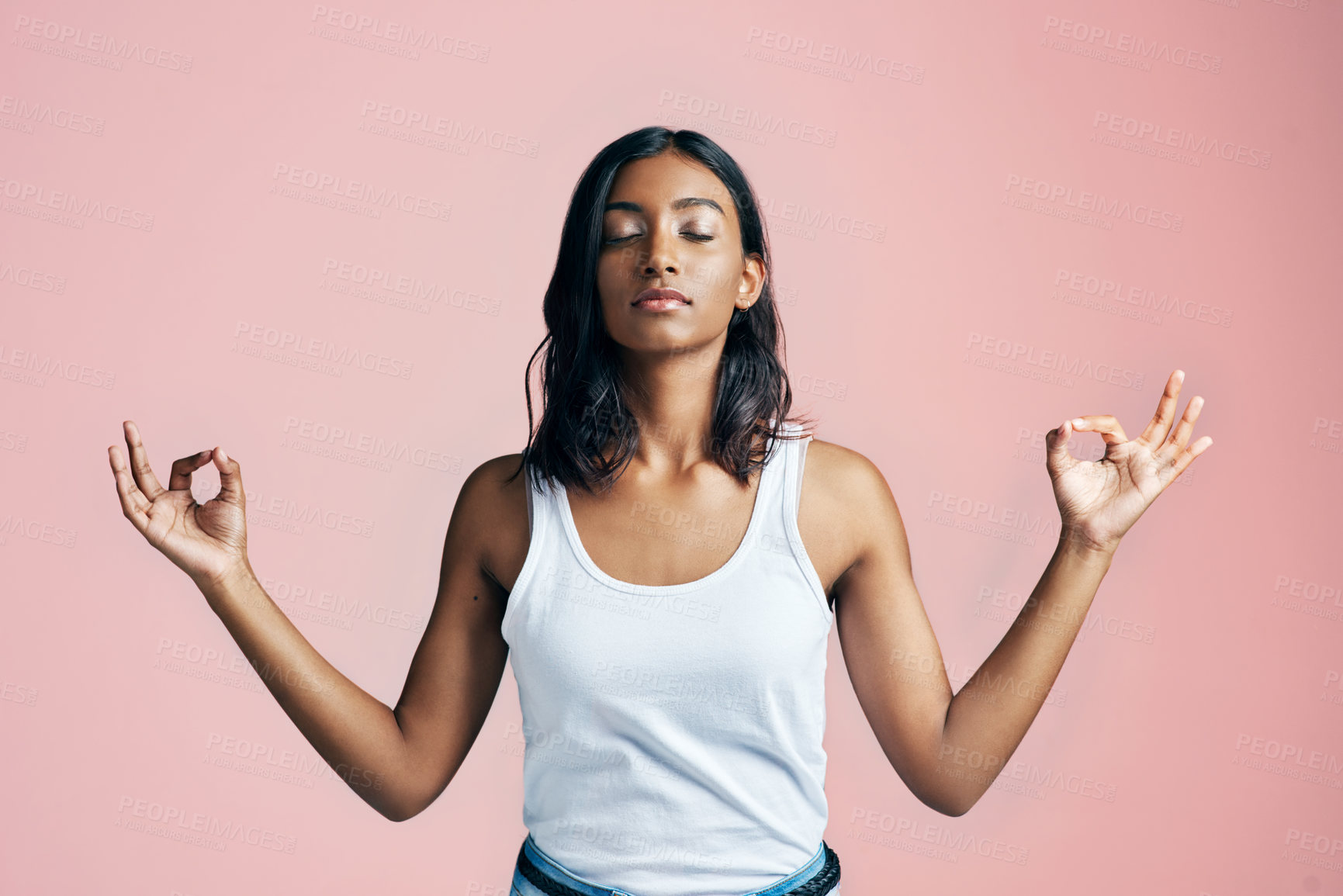 Buy stock photo Studio shot of a beautiful young woman meditating against a pink background