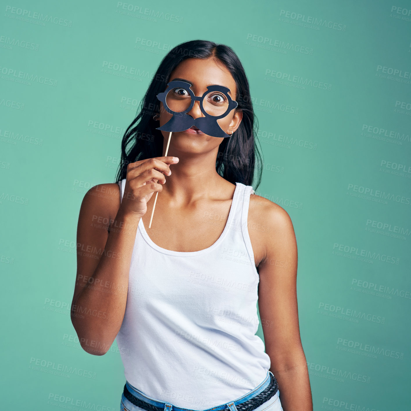 Buy stock photo Studio portrait of a beautiful young woman posing with prop glasses against a green background
