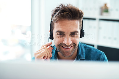 Buy stock photo Shot of an attractive young call centre agent working in his office