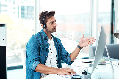 Buy stock photo Shot of an attractive young call centre agent working in his office