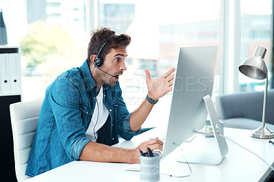 Buy stock photo Shot of a young male call centre agent looking shocked in his office