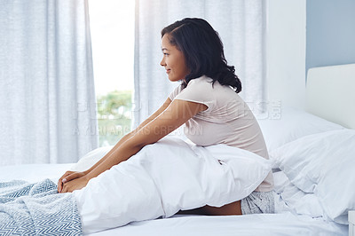 Buy stock photo Shot of a happy young woman waking up in the morning in bed