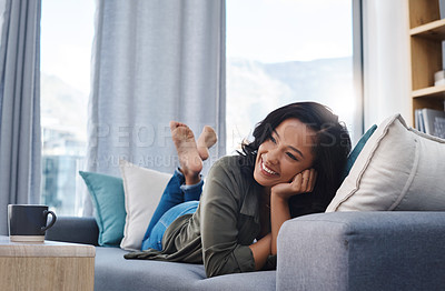 Buy stock photo Shot of an attractive young woman relaxing on the sofa at home