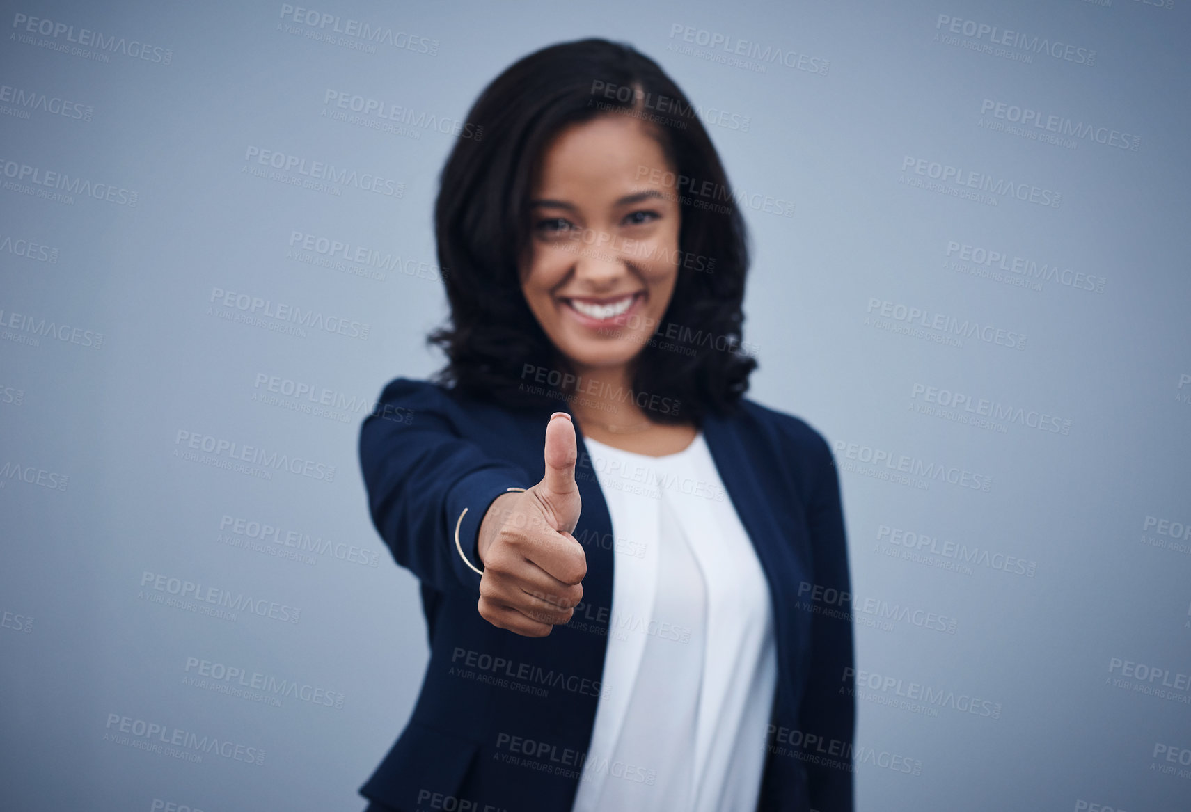 Buy stock photo Studio portrait of a young businesswoman showing thumbs up against a grey background