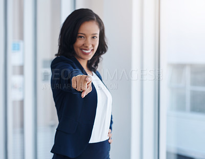 Buy stock photo Portrait of a young businesswoman pointing towards the camera in an office