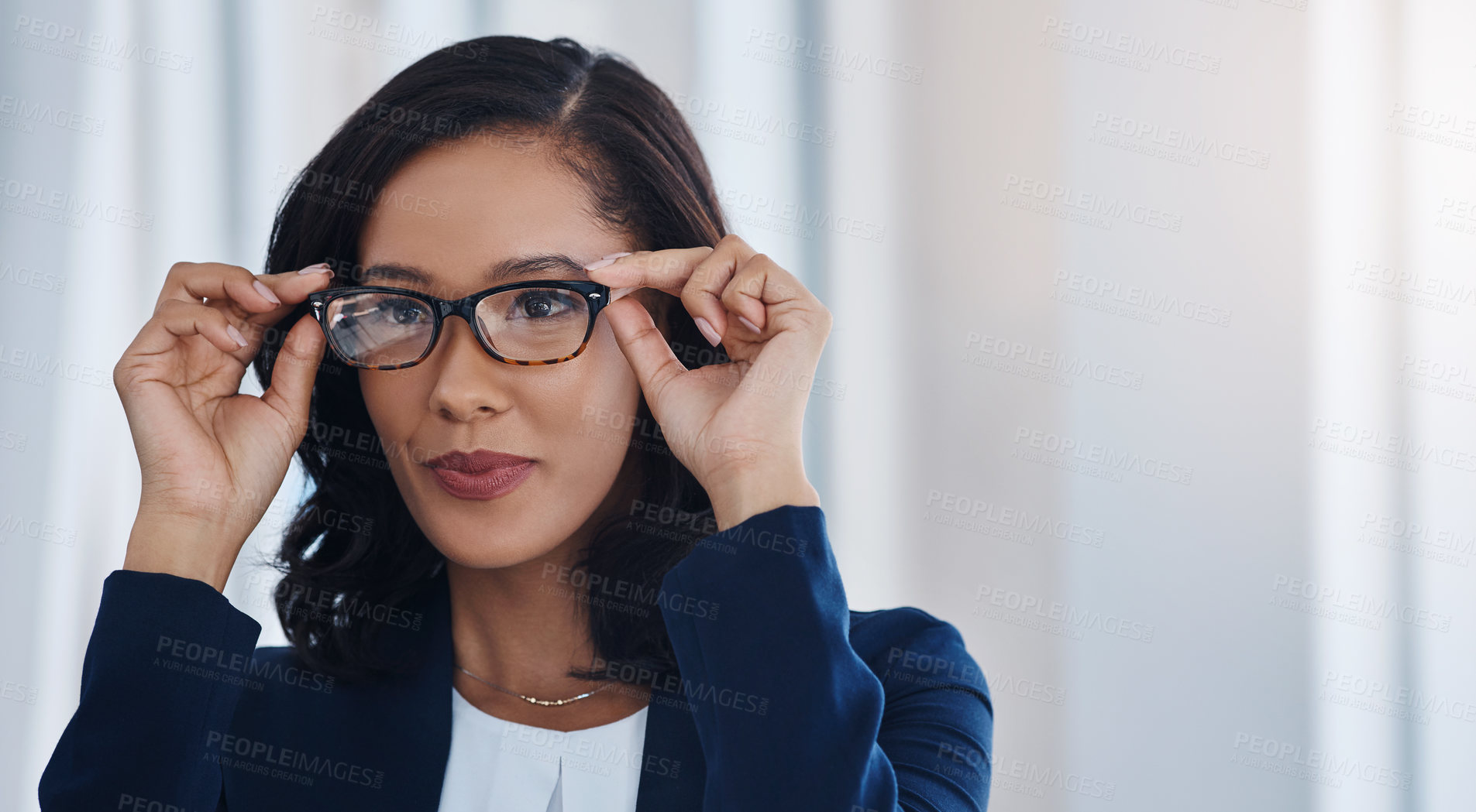 Buy stock photo Shot of a young businesswoman holding a pair of spectacles in an office