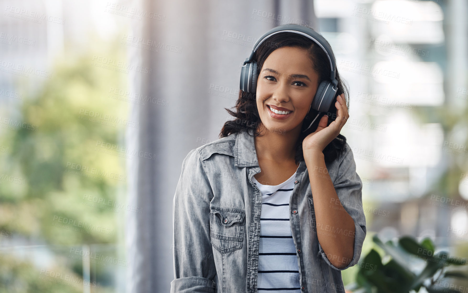 Buy stock photo Portrait of a young woman wearing headphones while listening to music at home