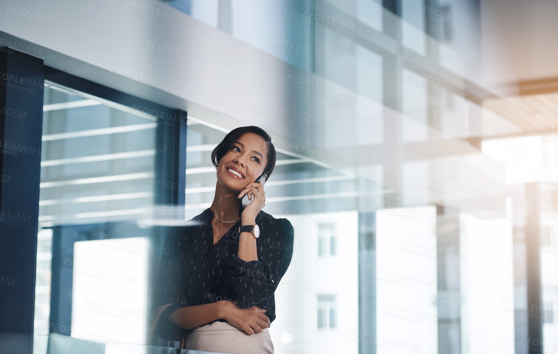 Buy stock photo Shot of a young businesswoman talking on a cellphone in an office