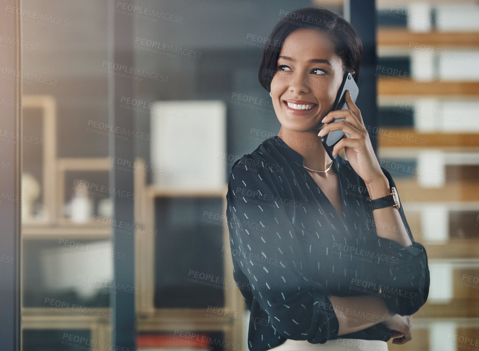 Buy stock photo Shot of a young businesswoman talking on a cellphone in an office