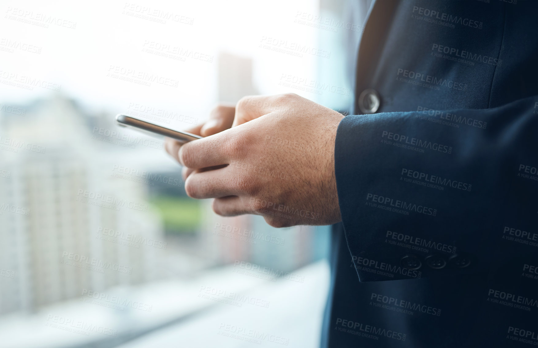 Buy stock photo Cropped shot of a businessman using a mobile phone in a modern office