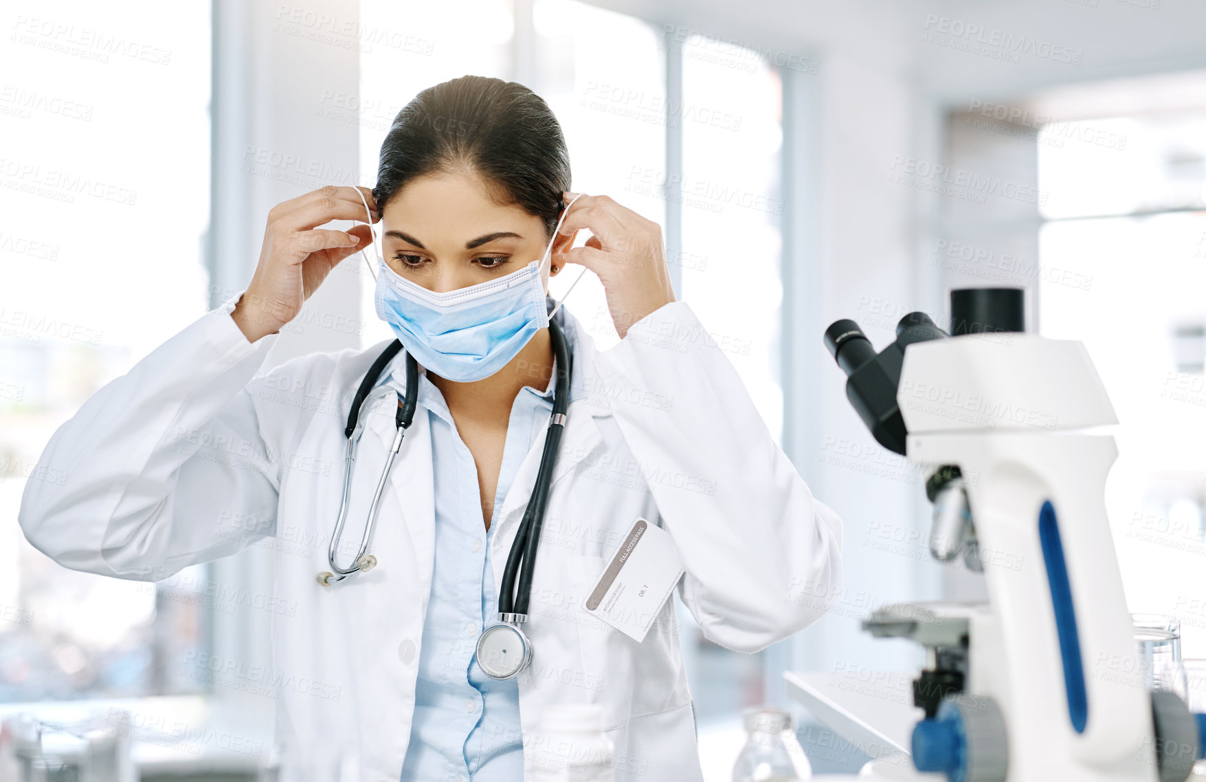 Buy stock photo Woman, doctor and mask with microscope for biology, forensic science or medical discovery at laboratory. Female person, biologist or scientist with protection for virus, health and safety at lab