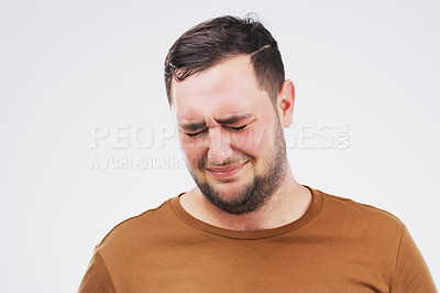 Buy stock photo Studio shot of a young man crying while standing against a gray background