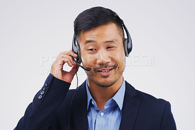 Buy stock photo Talking, call center and Asian man in studio with thinking, headset and happy on white background. Male person, consultant and advisor for support, information and crm with mic for communication