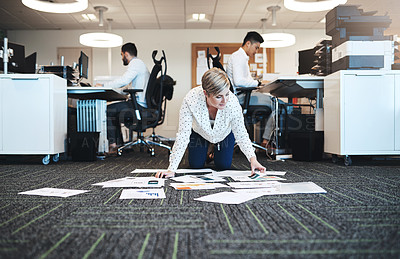 Buy stock photo Full length shot of an attractive young businesswoman working with paperwork on the floor in the office