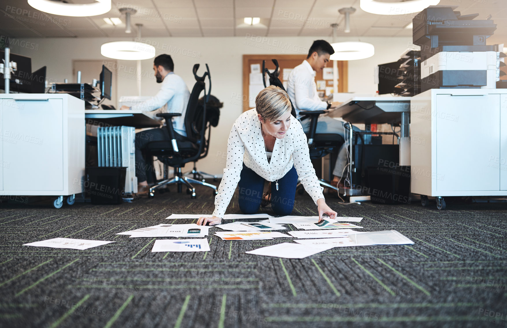 Buy stock photo Full length shot of an attractive young businesswoman working with paperwork on the floor in the office