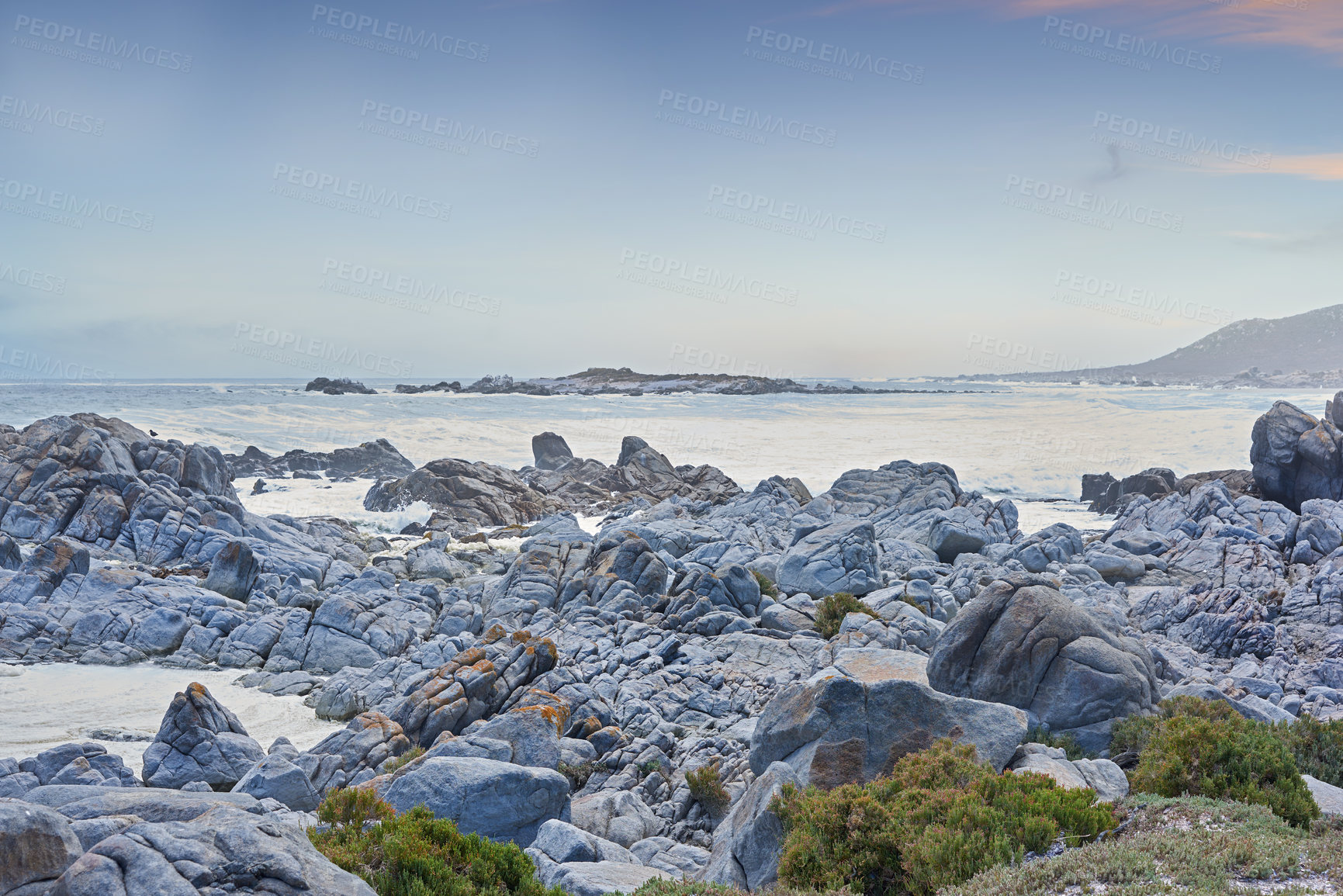 Buy stock photo Rocky coastline against blue horizon at sunset in South Africa. Peaceful and scenic landscape of boulders in the calm ocean water near Cape Town. Quiet location for vacation or nature walk in summer