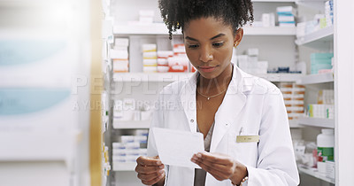 Buy stock photo Cropped shot of an attractive young pharmacist looking at a prescription in a chemist